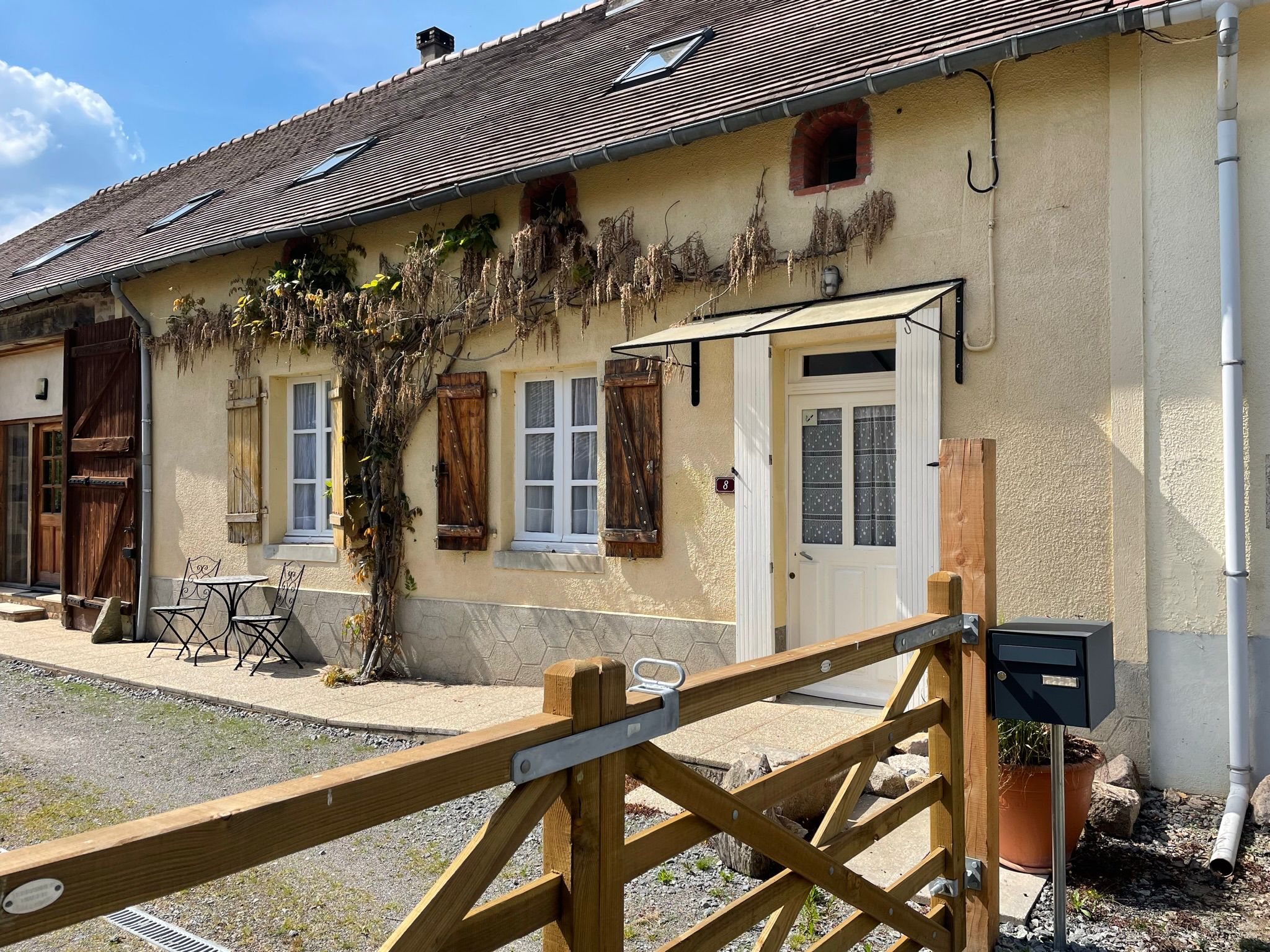 Entree van Laisser Faire met houten poort en Franse gevel